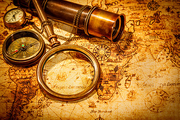 Image showing Vintage magnifying glass lies on an ancient world map