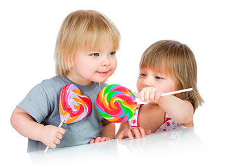 Image showing Babies eating a sticky lollipop