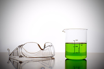 Image showing Measuring glass with safety goggles