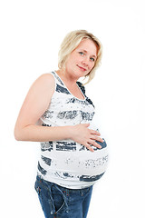 Image showing beautiful pregnant woman tenderly holding her tummy isolated on white background