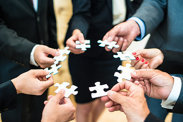 Image showing Teamwork - Business people solving a puzzle