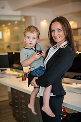 Image showing Businesswoman with small child in the office