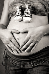Image showing pregnant woman with a child's shoe and hand heart shape