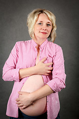 Image showing beautiful pregnant woman tenderly holding her tummy