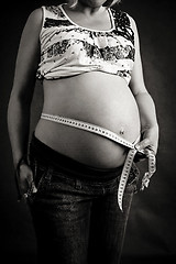 Image showing pregnant woman tenderly measuring her tummy 