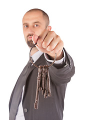 Image showing Man in suit giving old keys to a house