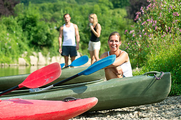 Image showing Woman sitting by kayak