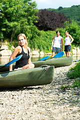 Image showing Woman sitting by kayak