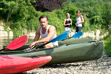 Image showing Man sitting by kayak