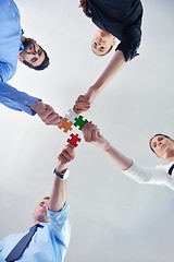 Image showing Group of business people assembling jigsaw puzzle