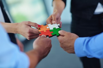 Image showing Group of business people assembling jigsaw puzzle