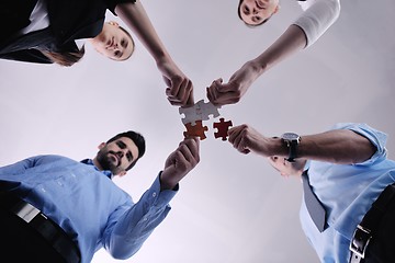 Image showing Group of business people assembling jigsaw puzzle