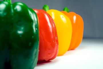 Image showing Four wet peppers closeup straight on