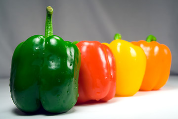 Image showing Four wet peppers closeup straight on