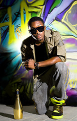 Image showing rapper sitting near wall