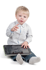 Image showing Little cute boy sitting with tablet computer