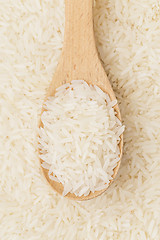 Image showing Uncooked white rice on wooden teaspoon