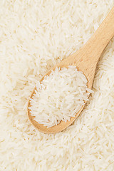 Image showing Uncooked white rice on wooden spoon