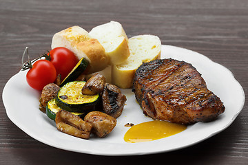 Image showing pork steak with sauce, mustard and grilled vegetables