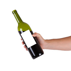 Image showing Hand holding a bottle of red wine