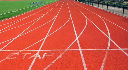 Image showing Red treadmill at the stadium with white lines 