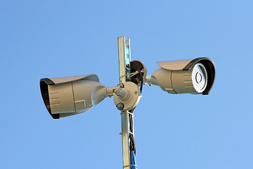 Image showing Two security cameras against blue sky