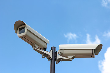 Image showing Two security cameras against blue sky