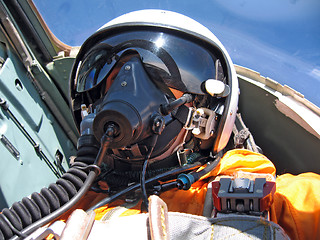 Image showing military pilot in the plane in a helmet in dark blue overalls ag