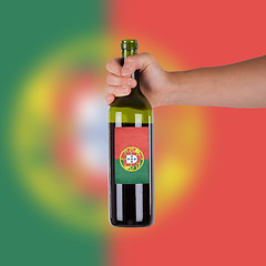 Image showing Hand holding a bottle of red wine