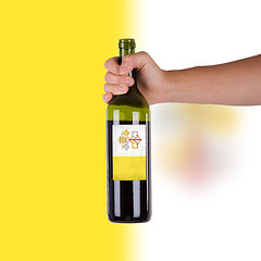 Image showing Hand holding a bottle of red wine