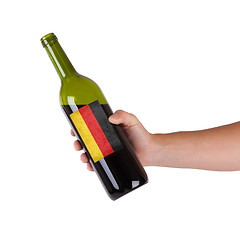 Image showing Hand holding a bottle of red wine