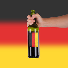 Image showing Hand holding a bottle of red wine