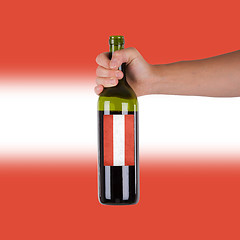 Image showing Hand holding a bottle of red wine