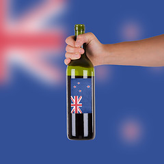 Image showing Hand holding a bottle of red wine