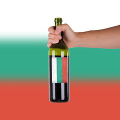 Image showing Hand holding a bottle of red wine