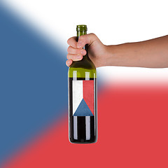 Image showing Hand holding a bottle of red wine