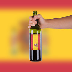 Image showing Hand holding a bottle of red wine