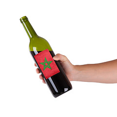 Image showing Hand holding a bottle of red wine