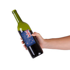 Image showing Hand holding a bottle of red wine