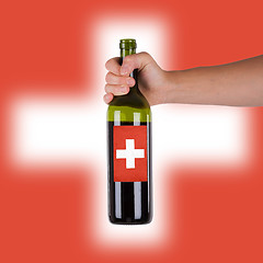 Image showing Hand holding a bottle of red wine