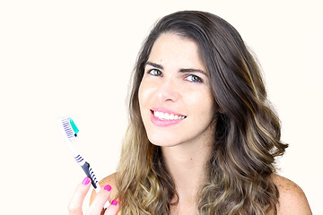 Image showing Beautiful young lady holding toothbrush and smiling