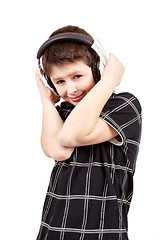 Image showing Portrait of a happy smiling young boy listening to music on head