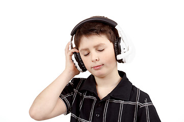 Image showing Portrait of a happy young boy listening to music on headphones