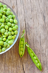 Image showing Fresh green peas on an old wooden background