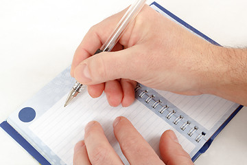 Image showing Close-up of hand beginning to write on notes