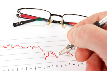 Image showing men analyzing business graph with glasses in the background