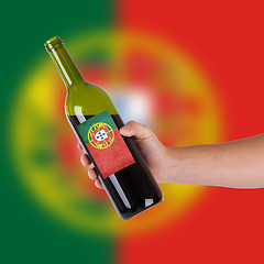 Image showing Hand holding a bottle of red wine