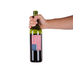 Image showing Hand holding a bottle of red wine