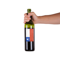 Image showing Hand holding a bottle of red wine