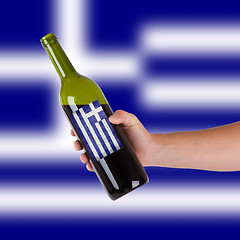 Image showing Hand holding a bottle of red wine